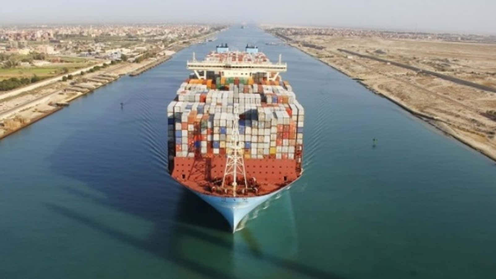 A Large Container Ship Is Traveling Down A Canal