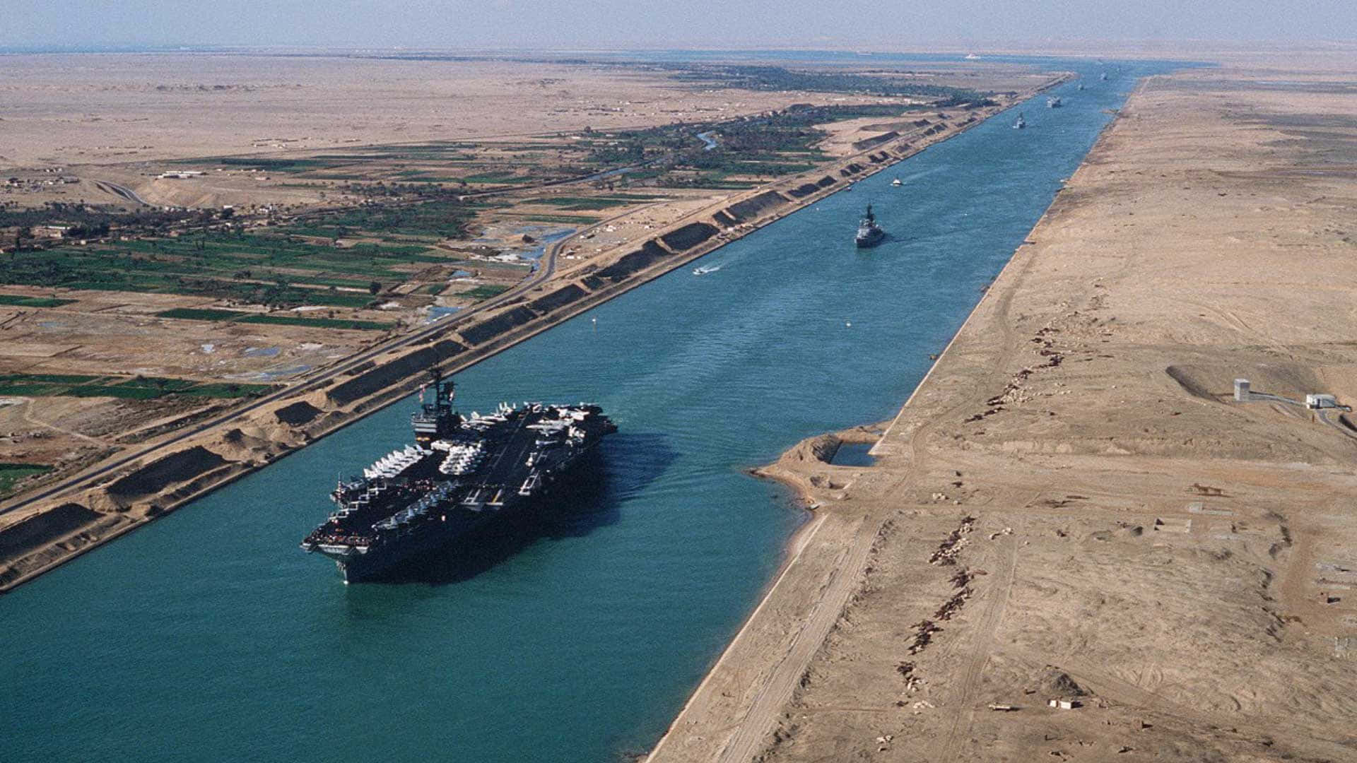 A Ship Is Traveling Down A Canal In The Desert