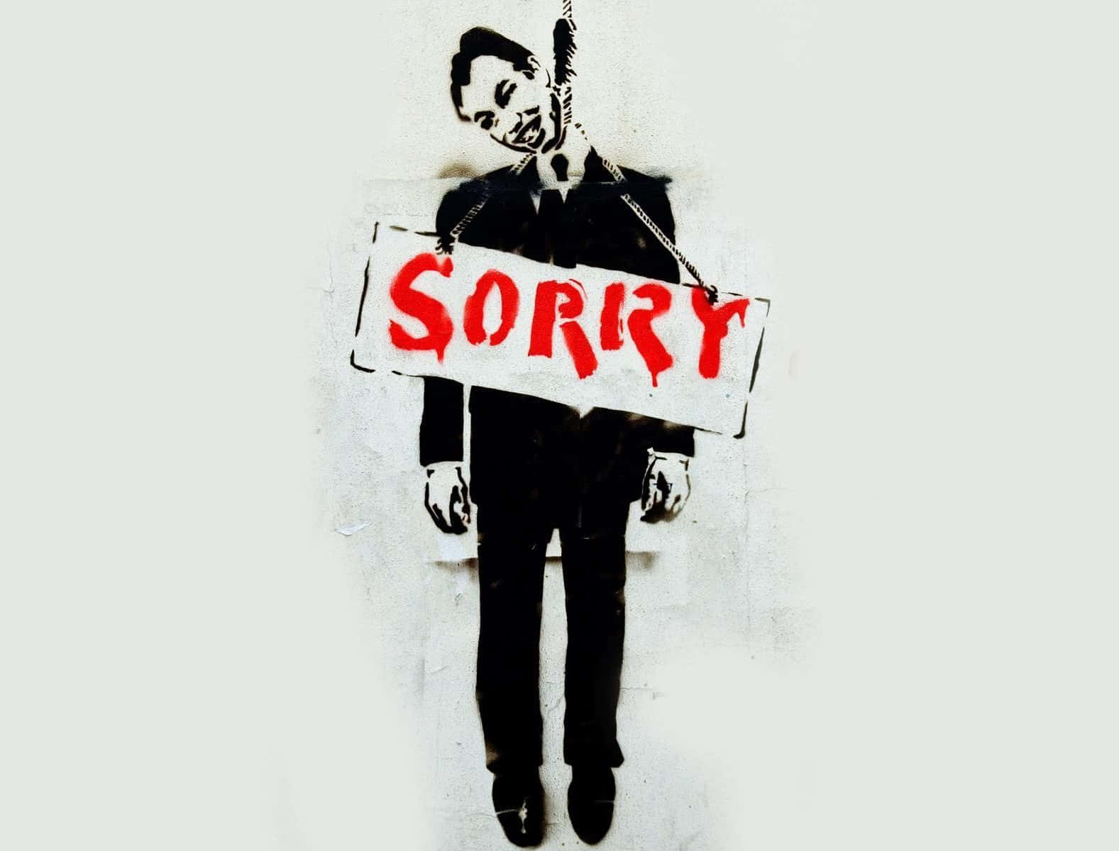 A Man Holding A Sign That Says Sorry Wallpaper