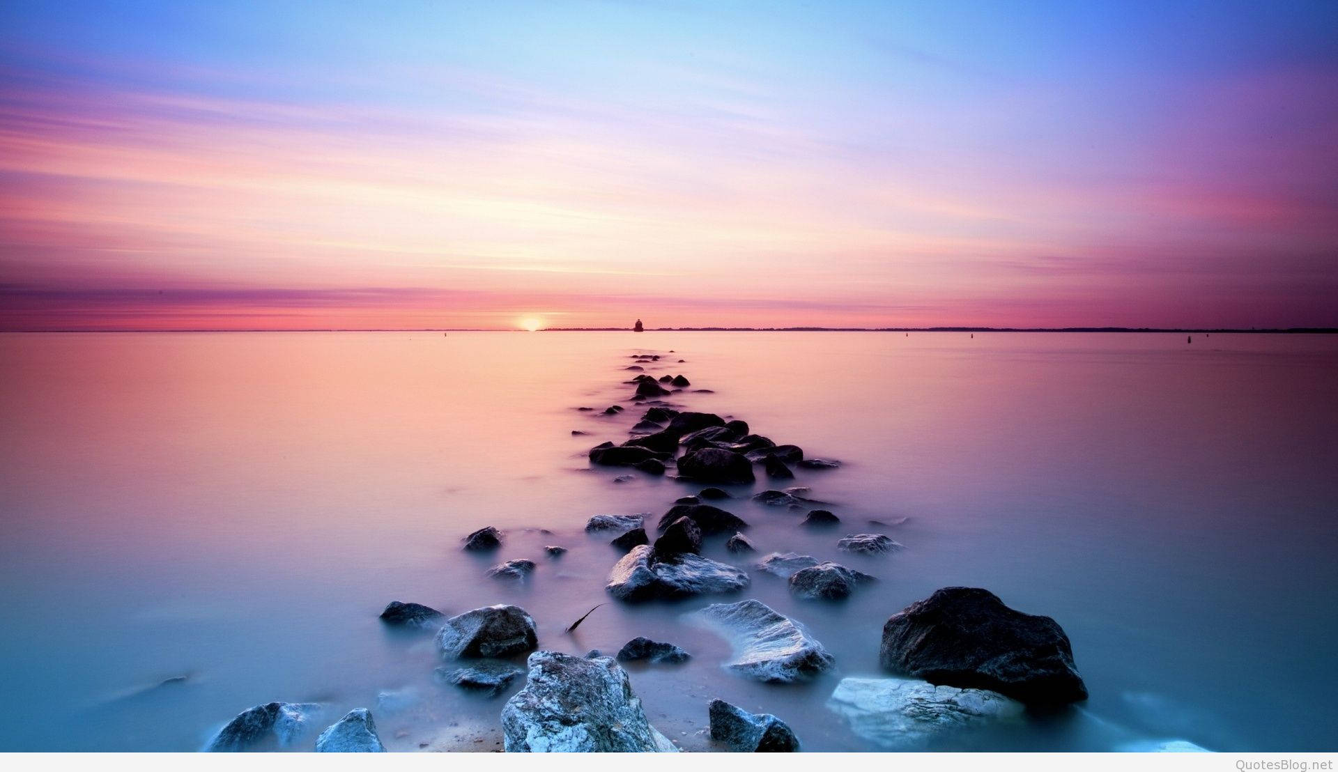A Long Exposure Of Rocks And Water At Sunset Wallpaper