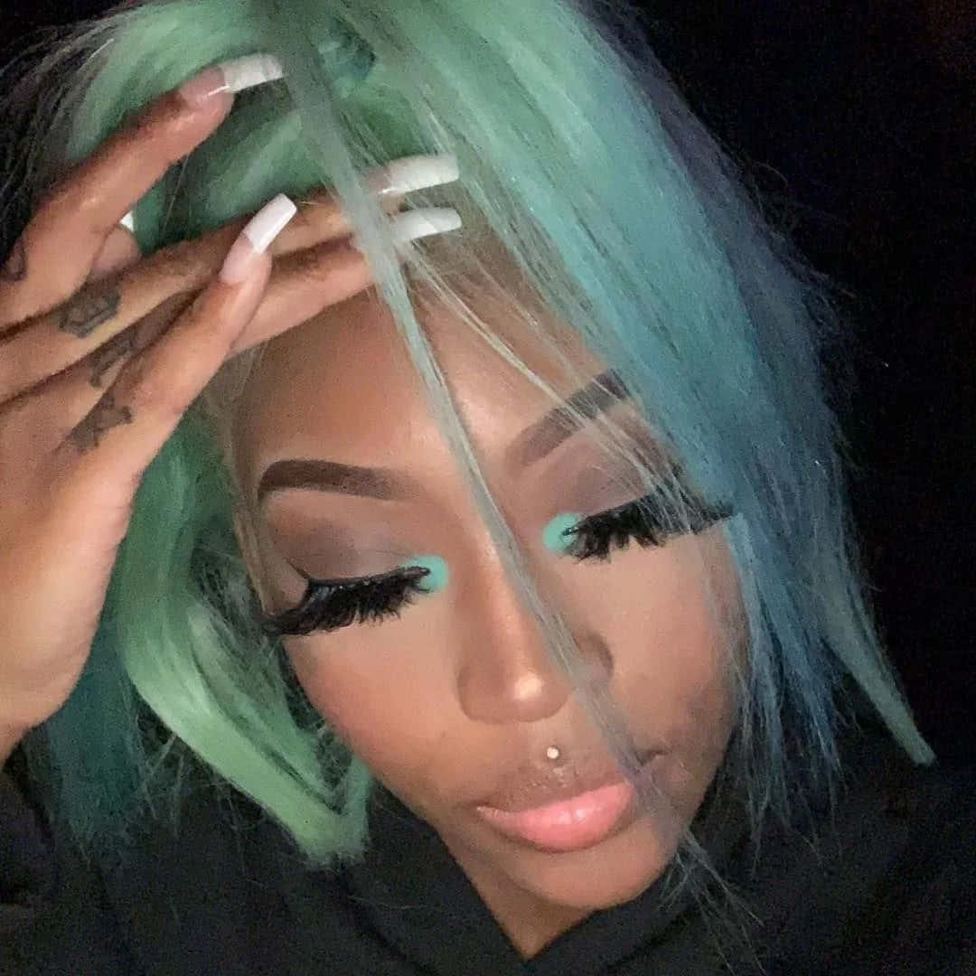 A Woman With Green Hair And A Tattoo On Her Face