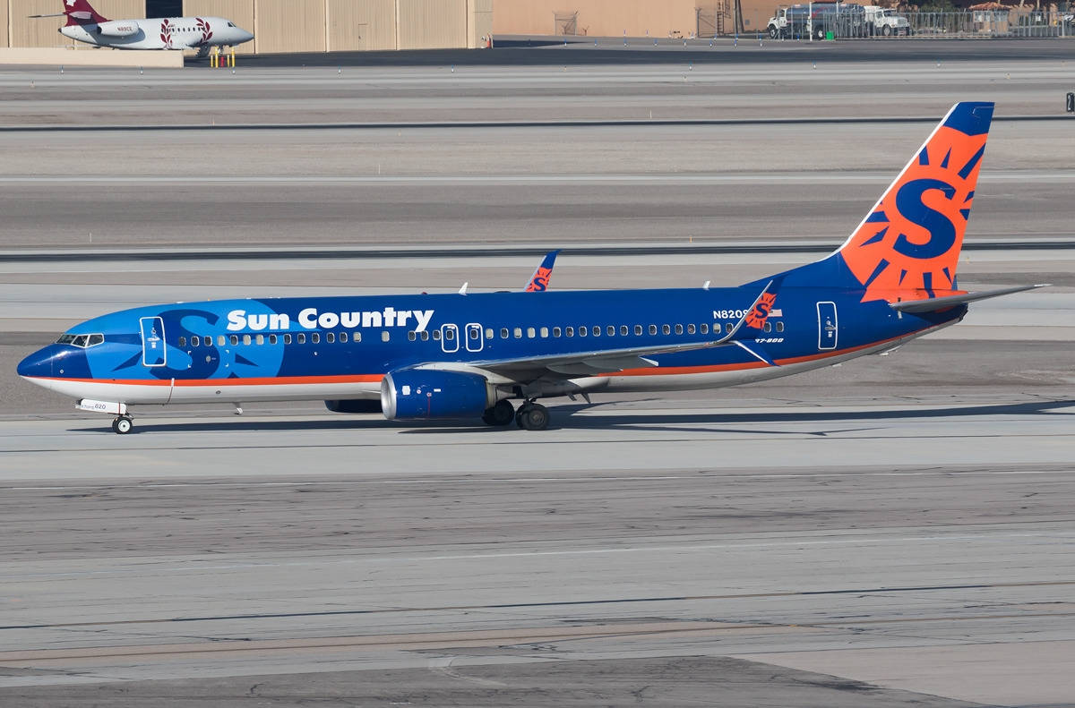 Aviónde Sun Country Airlines En La Pista Del Aeropuerto. Fondo de pantalla
