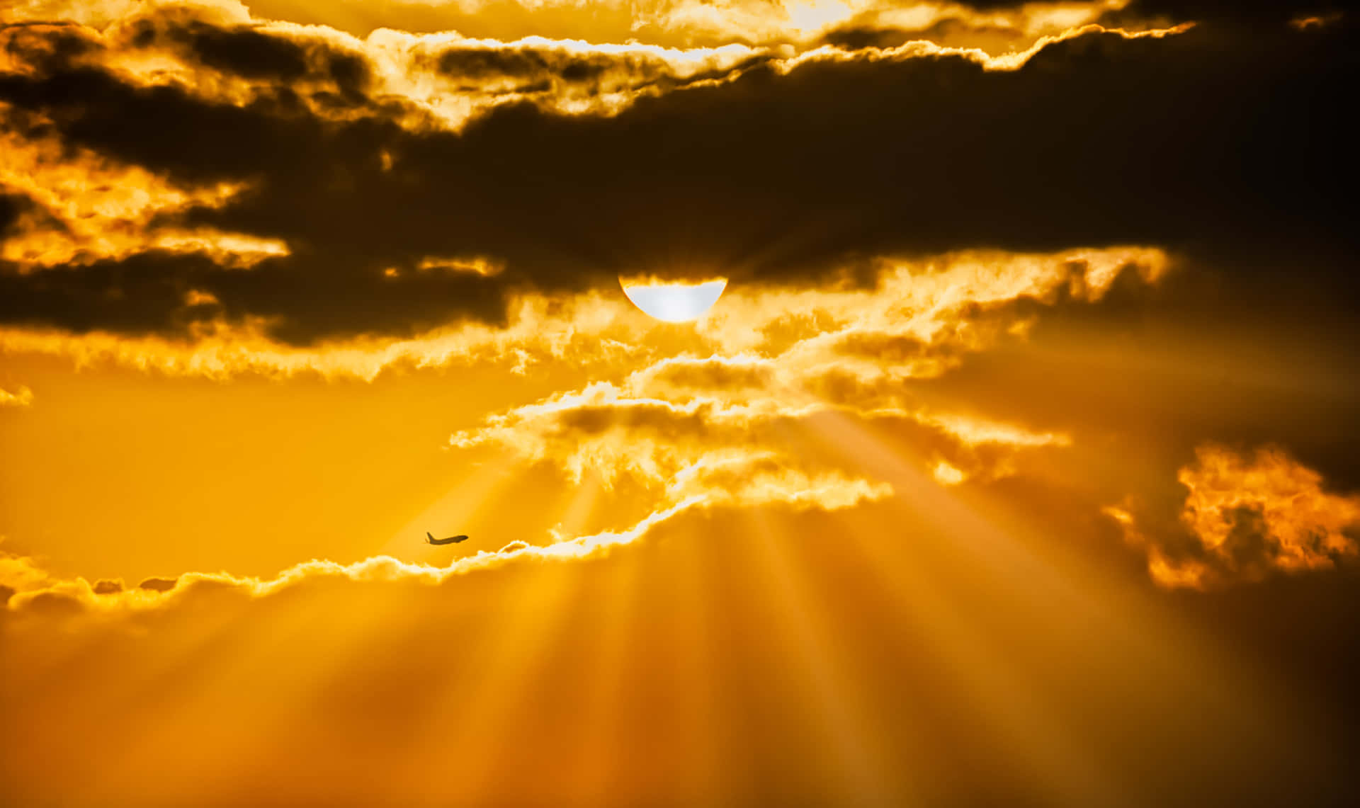 Majestic Sun Rays Illuminating a Golden Sky Wallpaper