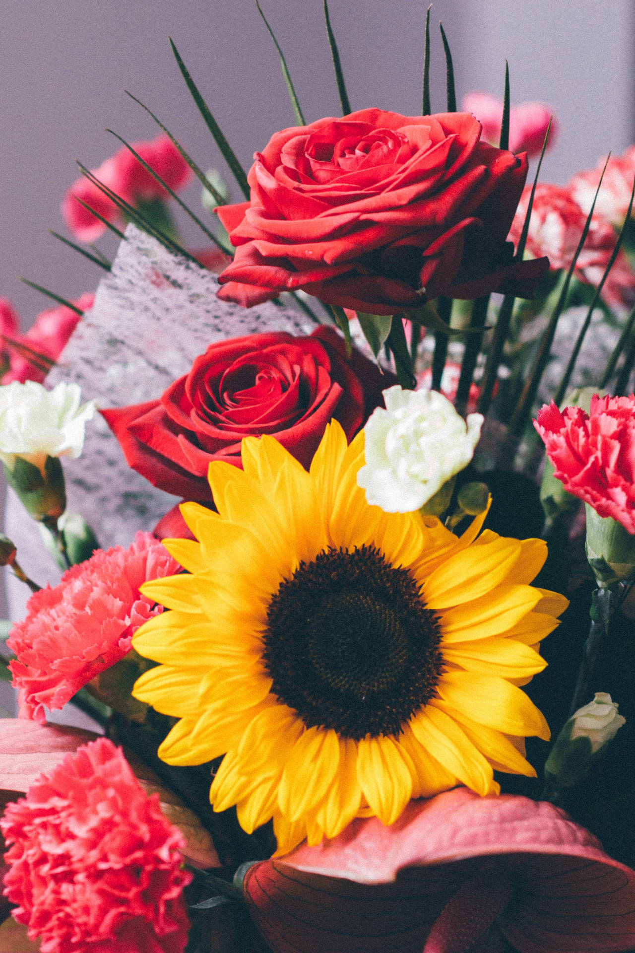 En buket af blomster med en solsikke i den. Wallpaper
