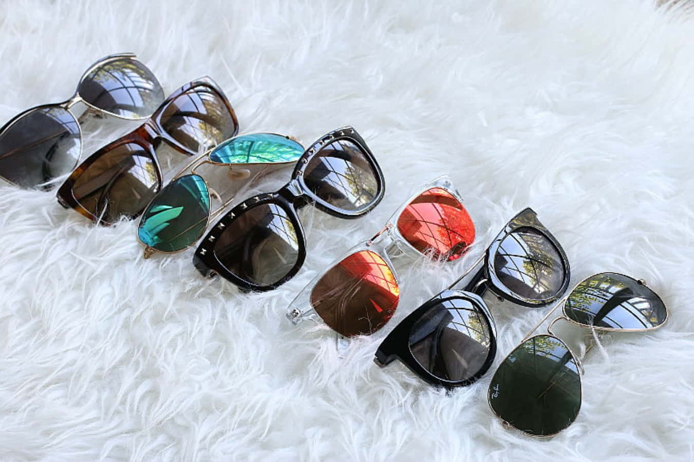 A Group Of Sunglasses Laying On A Fur Rug
