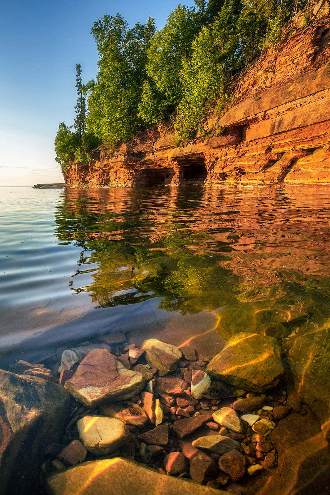 Sunlit_ Cliffside_and_ Calm_ Waters.jpg Wallpaper