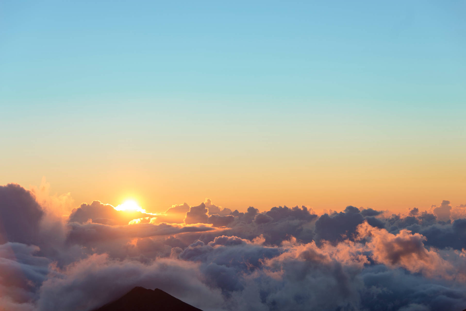 A Dramatic Breath-taking Sunrise Above the Clouds Wallpaper