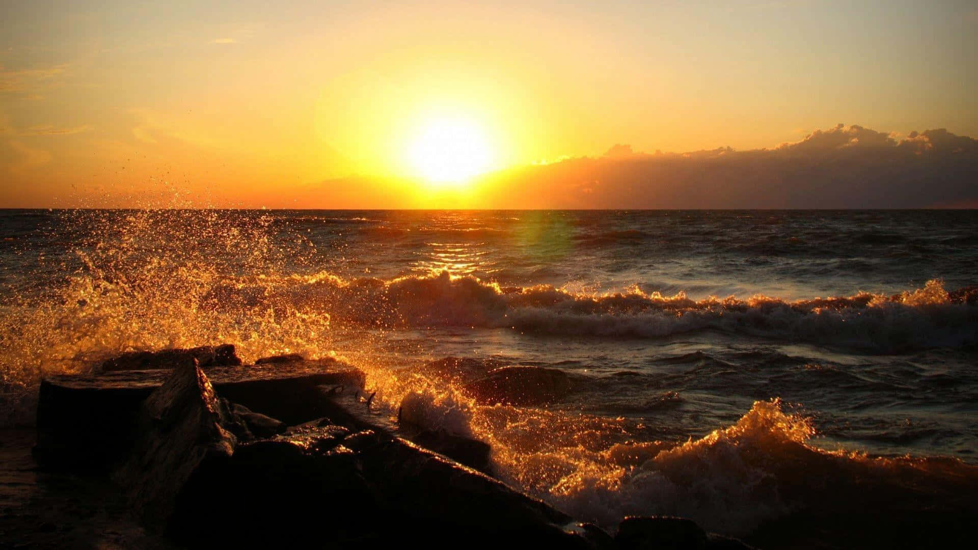 a sunset over the ocean with waves crashing