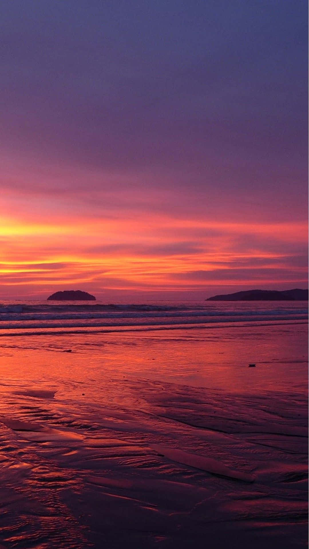 Einruhiger Sonnenuntergangs-blick Auf Den Strand Auf Einem Iphone Wallpaper