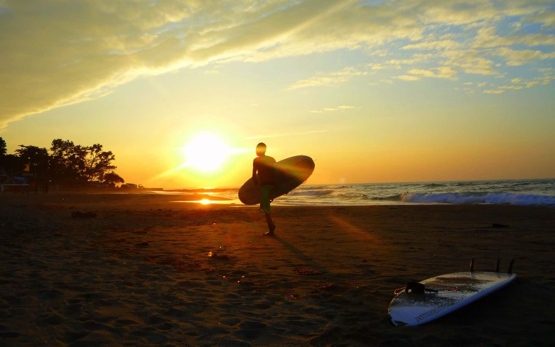 Imagengenial De Un Surfista En La Playa Al Atardecer