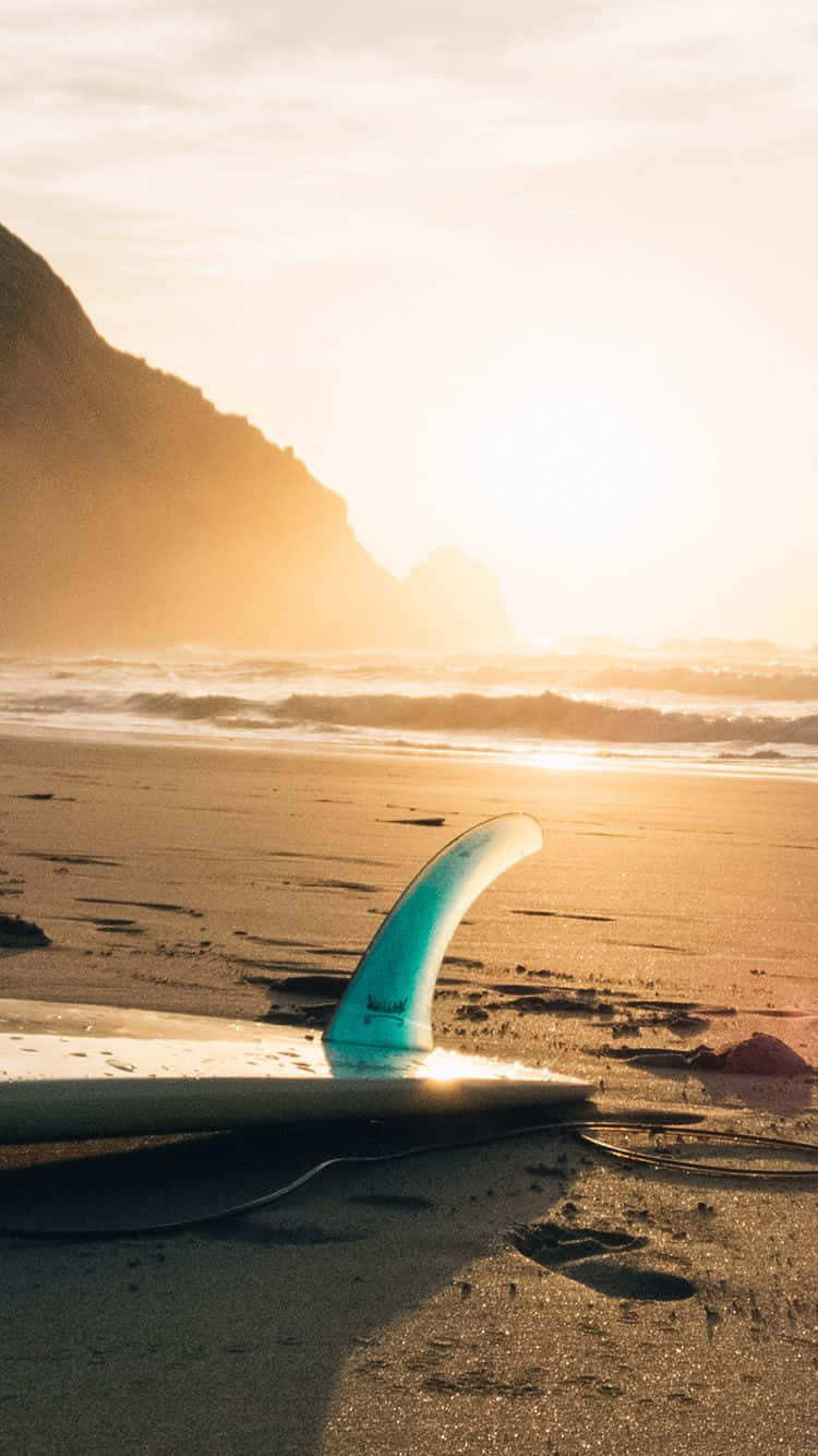 Immaginedi Una Spiaggia Al Tramonto Con Una Tavola Da Surf.
