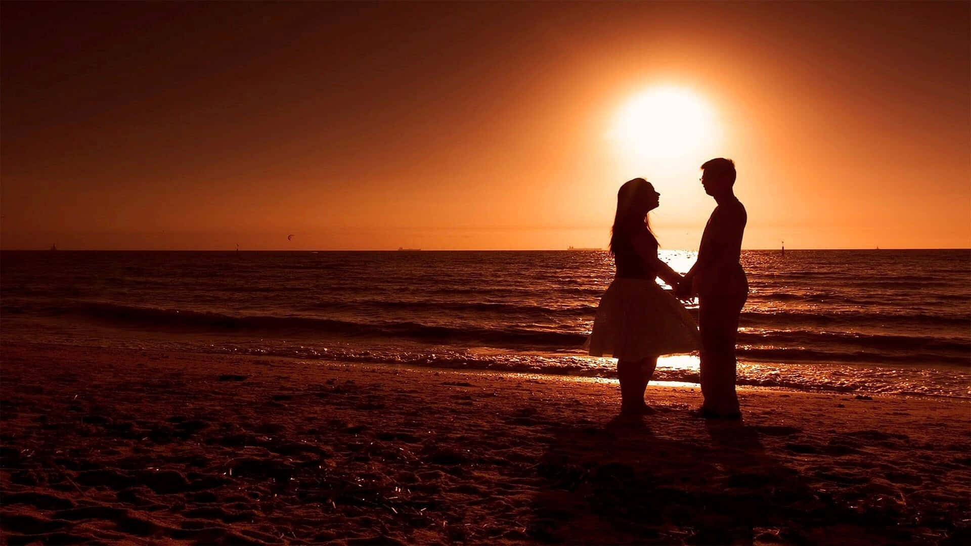 Solnedgångsbild Av Ungt Par På Stranden Som Håller Händerna.