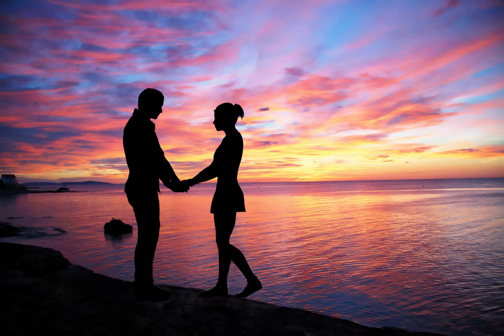Couple sitting at beach, silhouette in sunset, love and friendship, holding  the sun Stock Photo - Alamy
