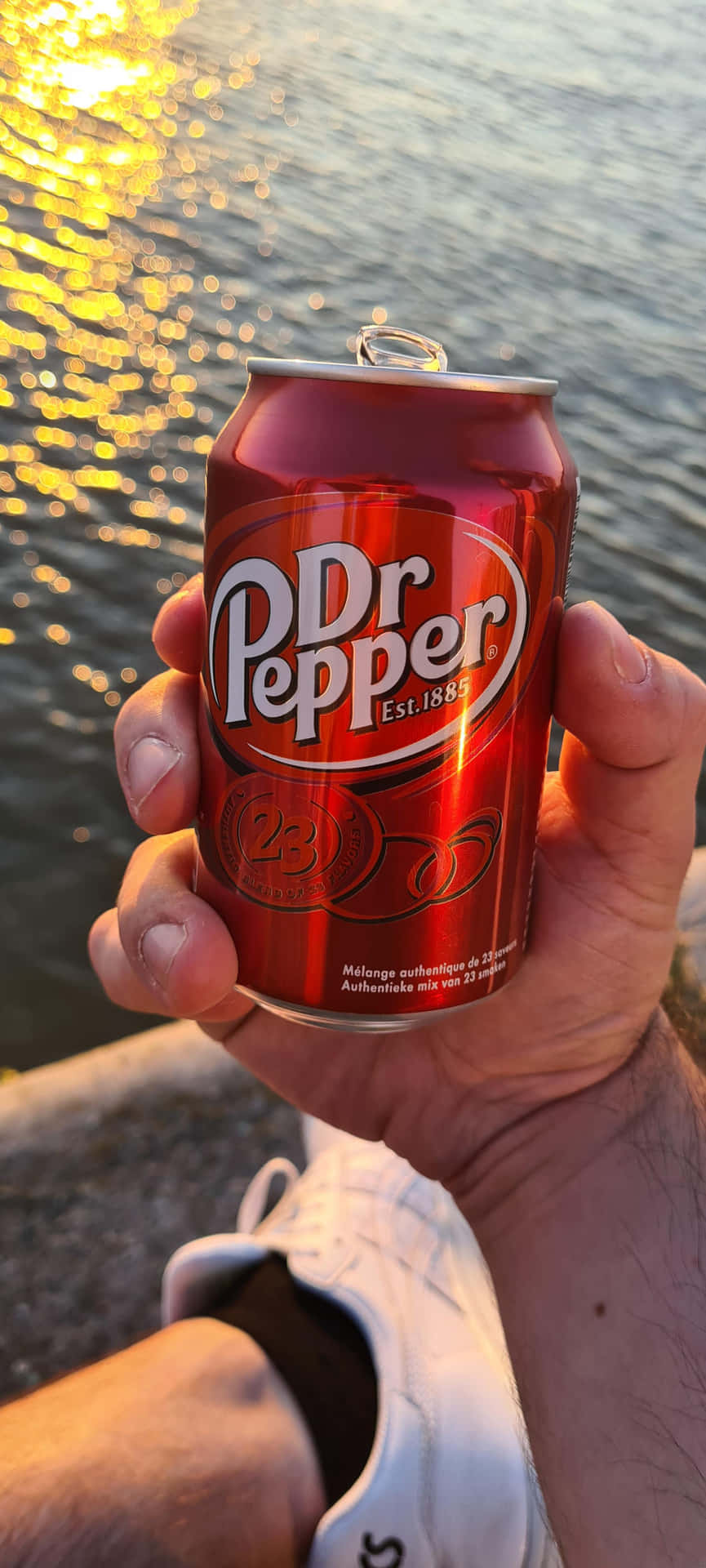 Sunset Dr Pepper Can Held Over Water Wallpaper