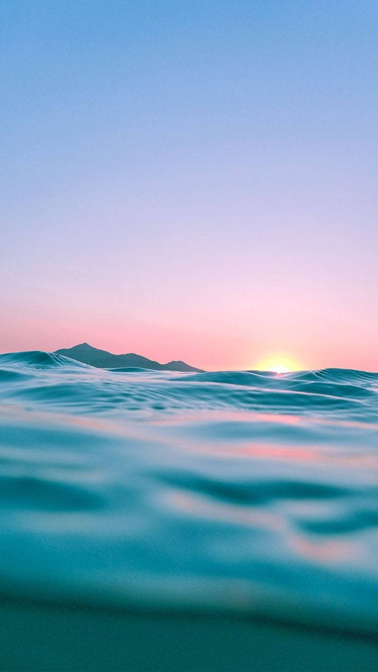 Solnedgang Iphone Display af Ocean Bølger Wallpaper