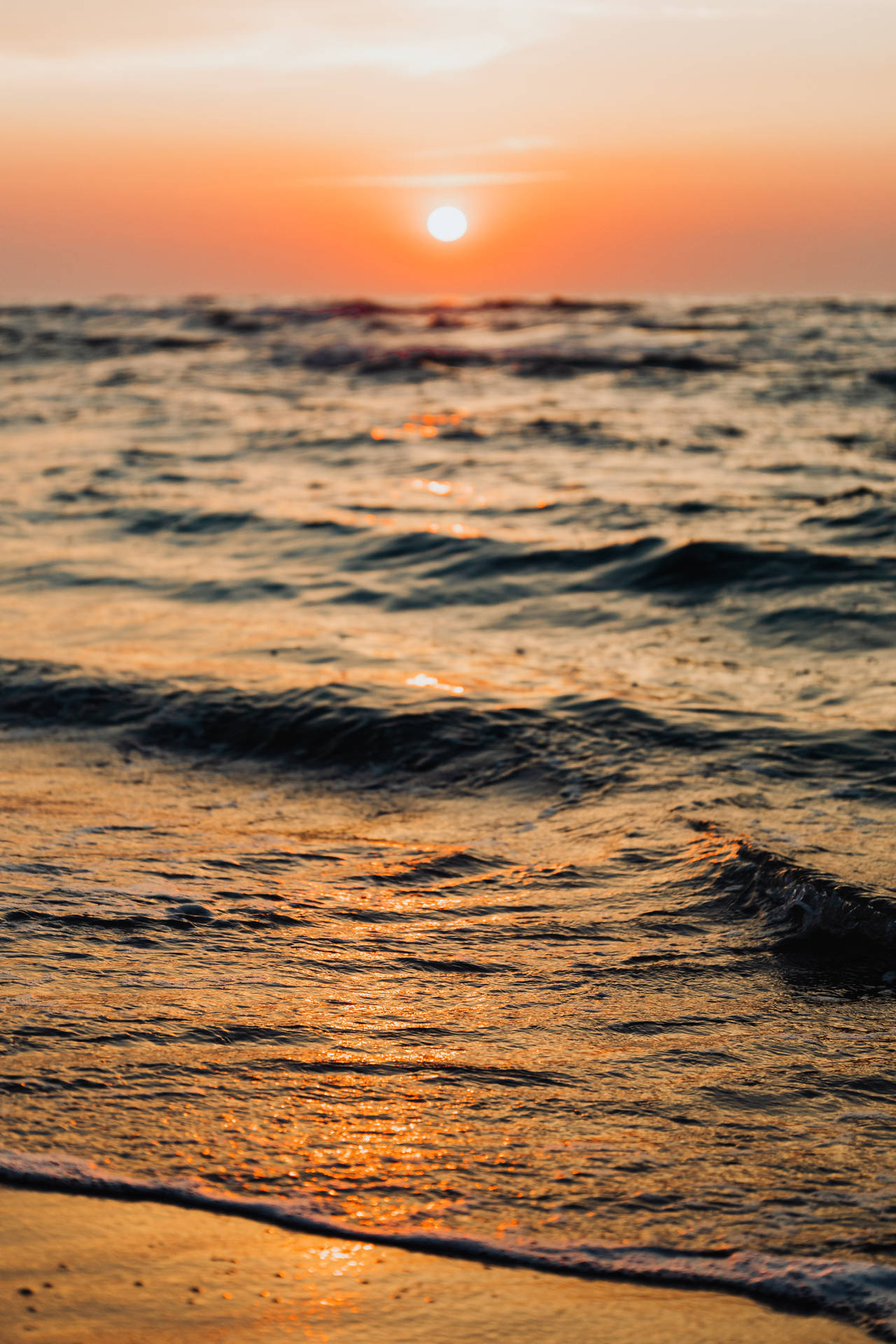 Solnedgang over strandbølge iPhone tapet Wallpaper