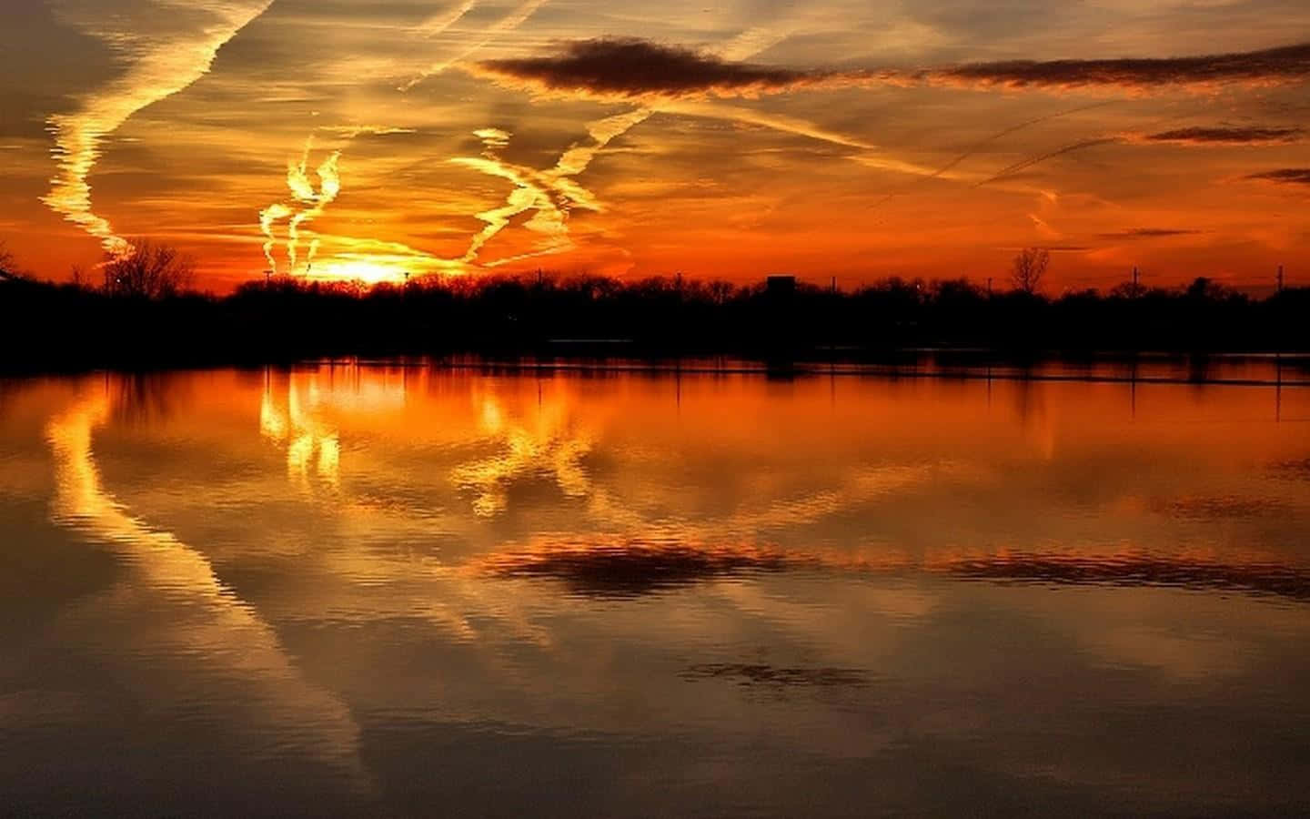 A serene sunset reflection on a calm lake Wallpaper
