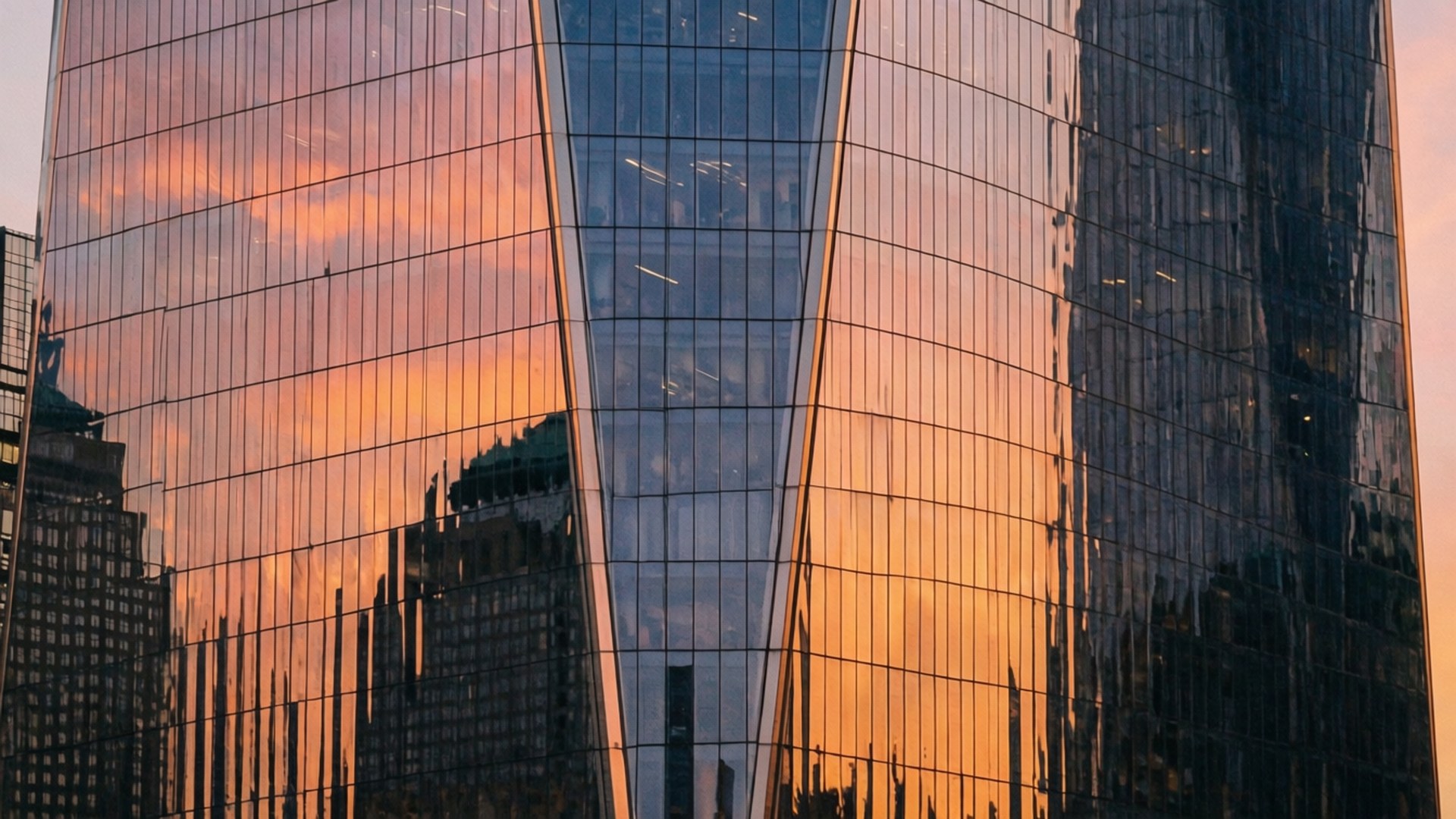 Abstract close-up of Freedom Tower glass reflecting sunset colors.