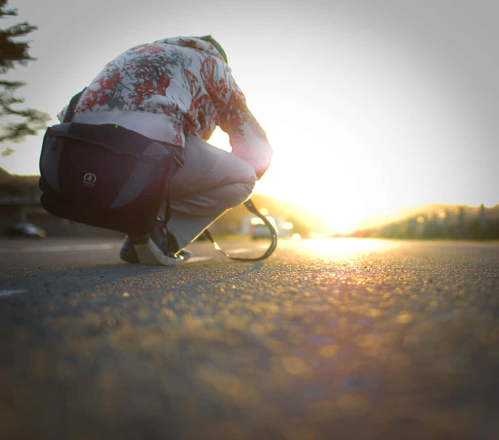 Sunset Streetside Crouching Person Wallpaper
