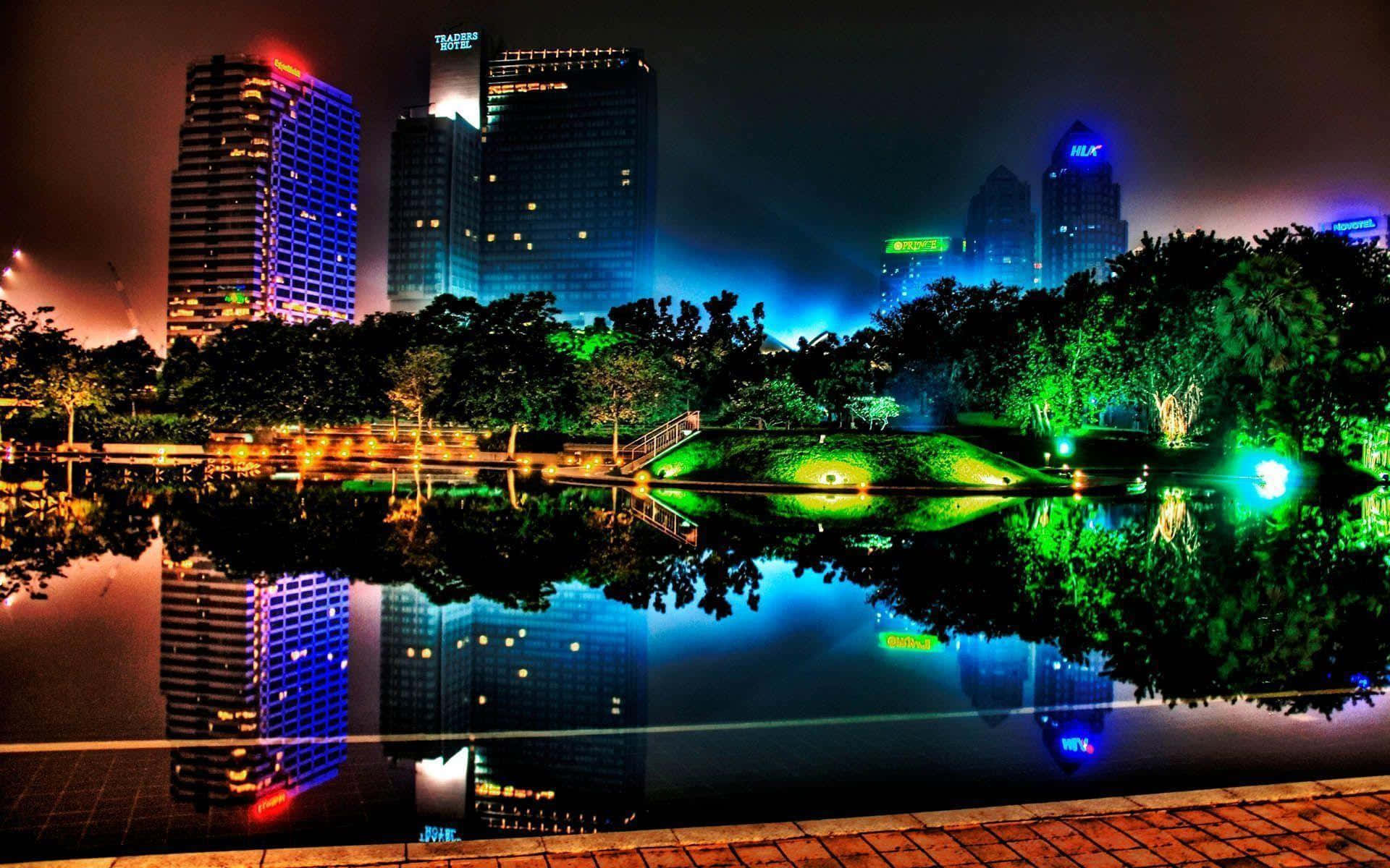 En by om natten med lys, der reflekteres i vandet. Wallpaper