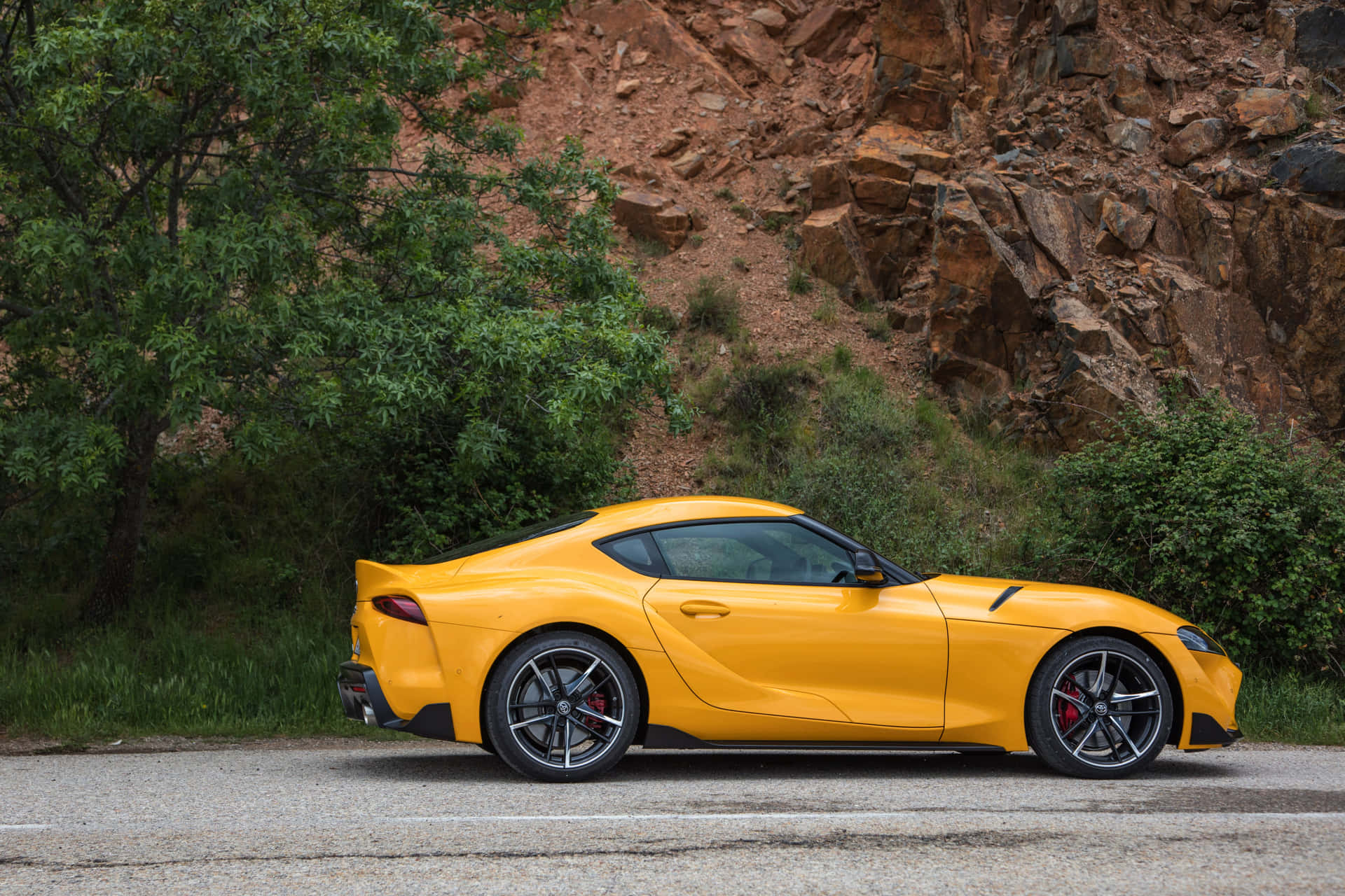 A stunning Toyota Supra sports car on display in a picturesque landscape.