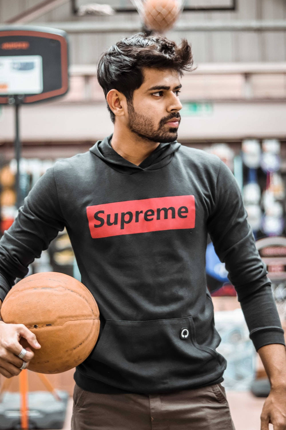 Download Stylish Player in Supreme Hoodie Holding Basketball
