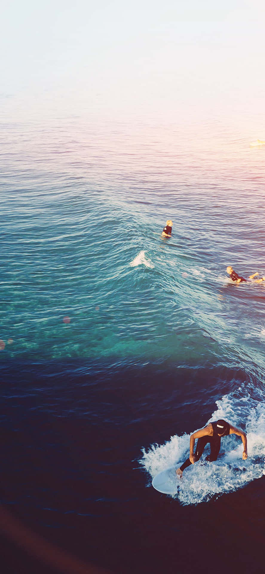 A Group Of People Riding A Wave In The Ocean Wallpaper