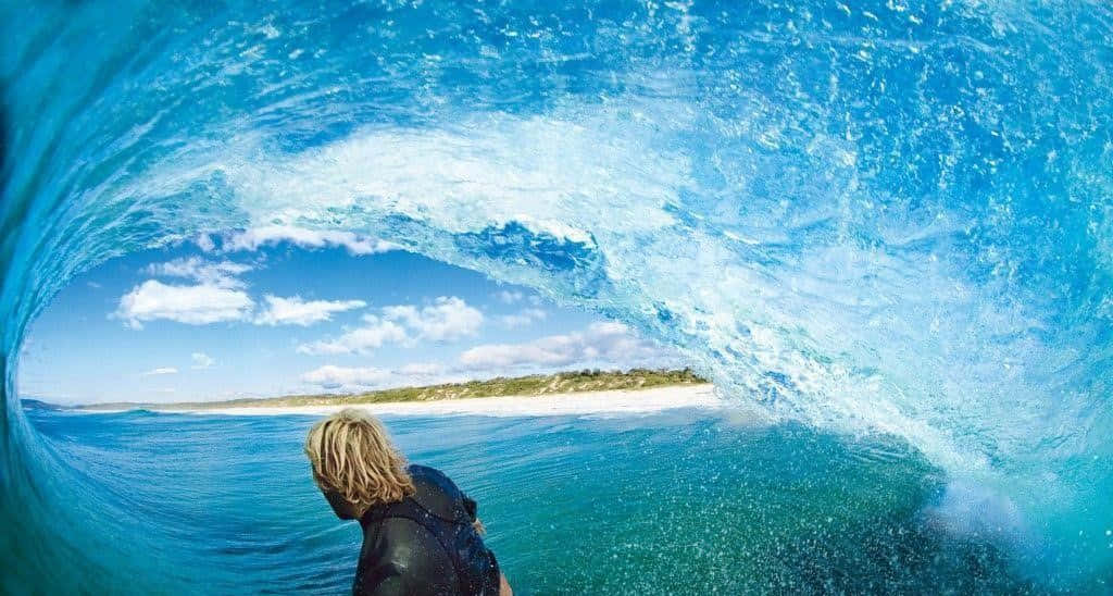 A Surfer Is Riding A Wave Through A Tube