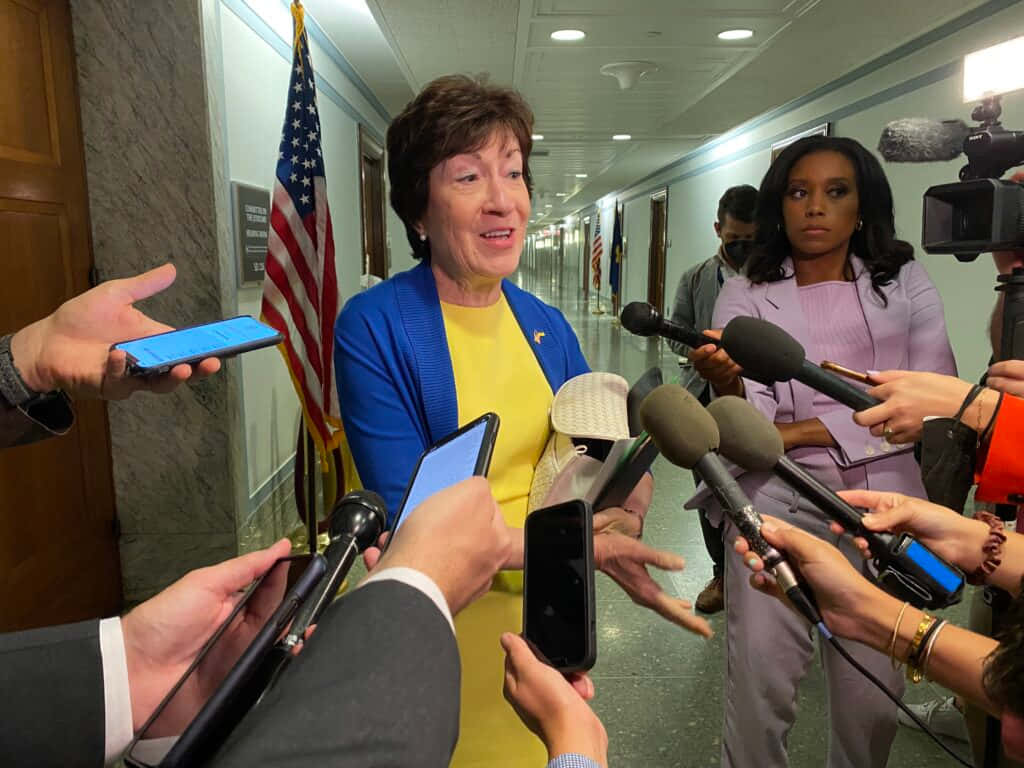 Senator Susan Collins engaged in a press briefing Wallpaper