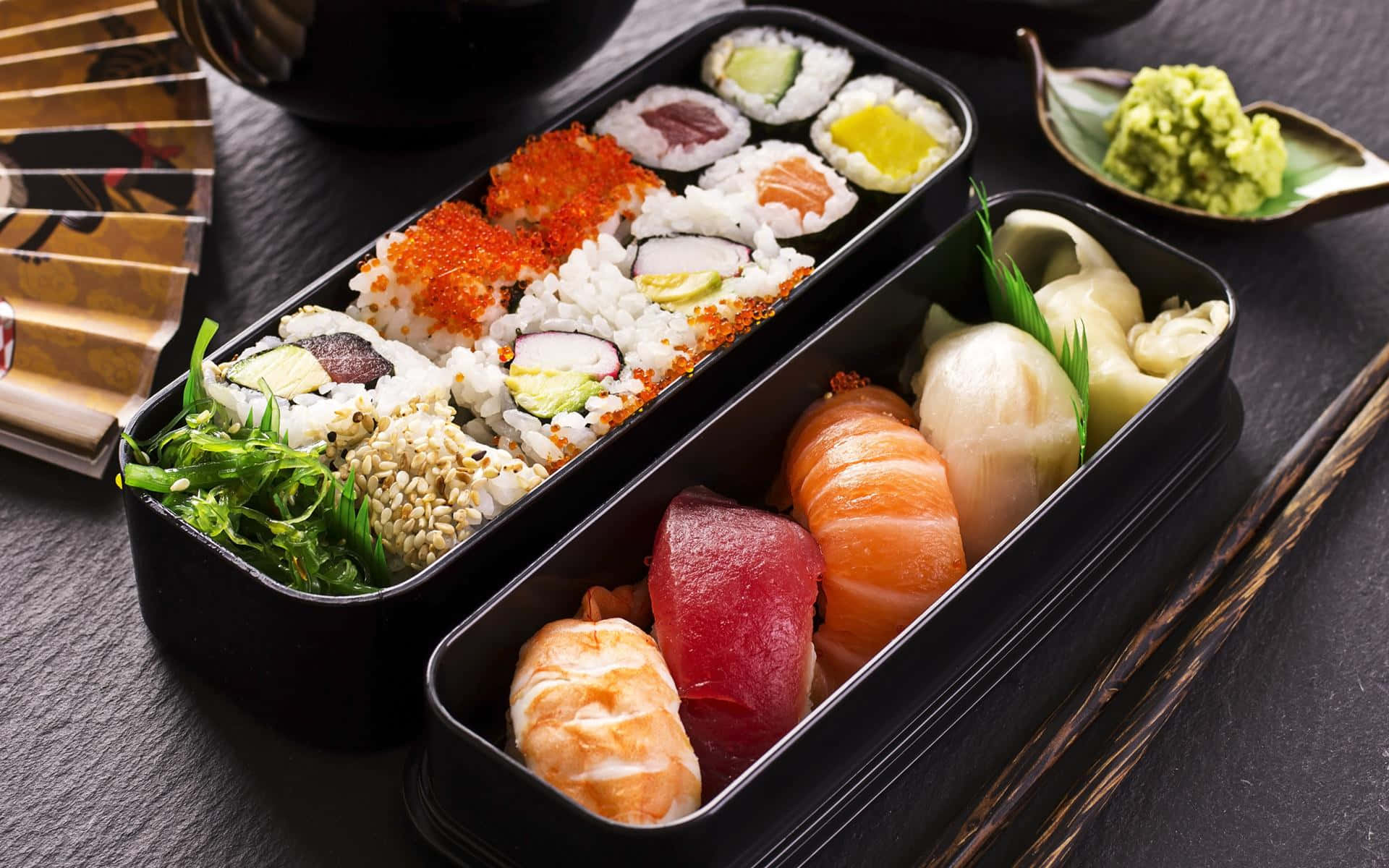 A beautifully presented sushi platter on a wooden table with chopsticks