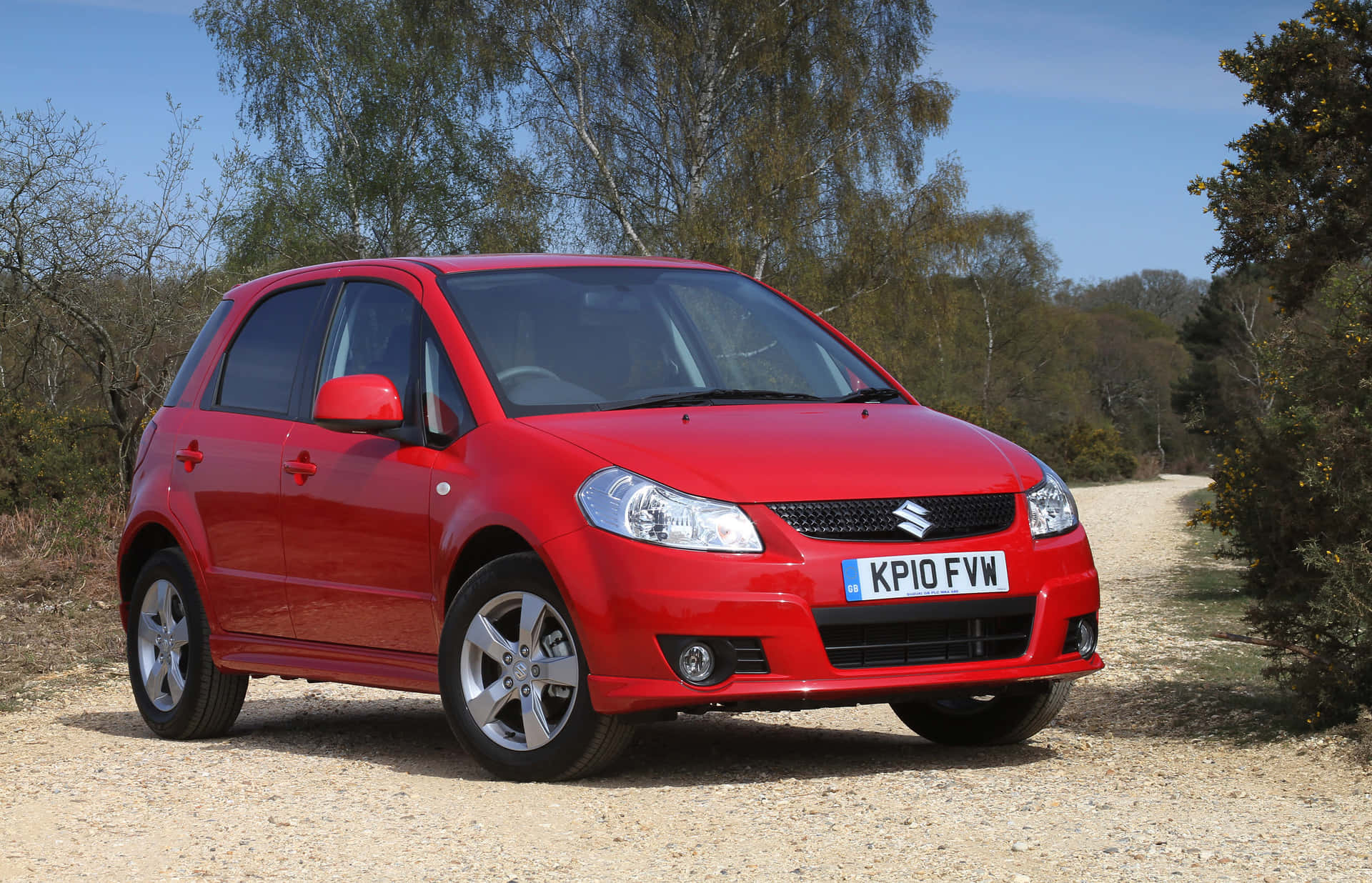 Suzuki Sx4 Compact Hatchback Mounted On A Serene Landscape Wallpaper