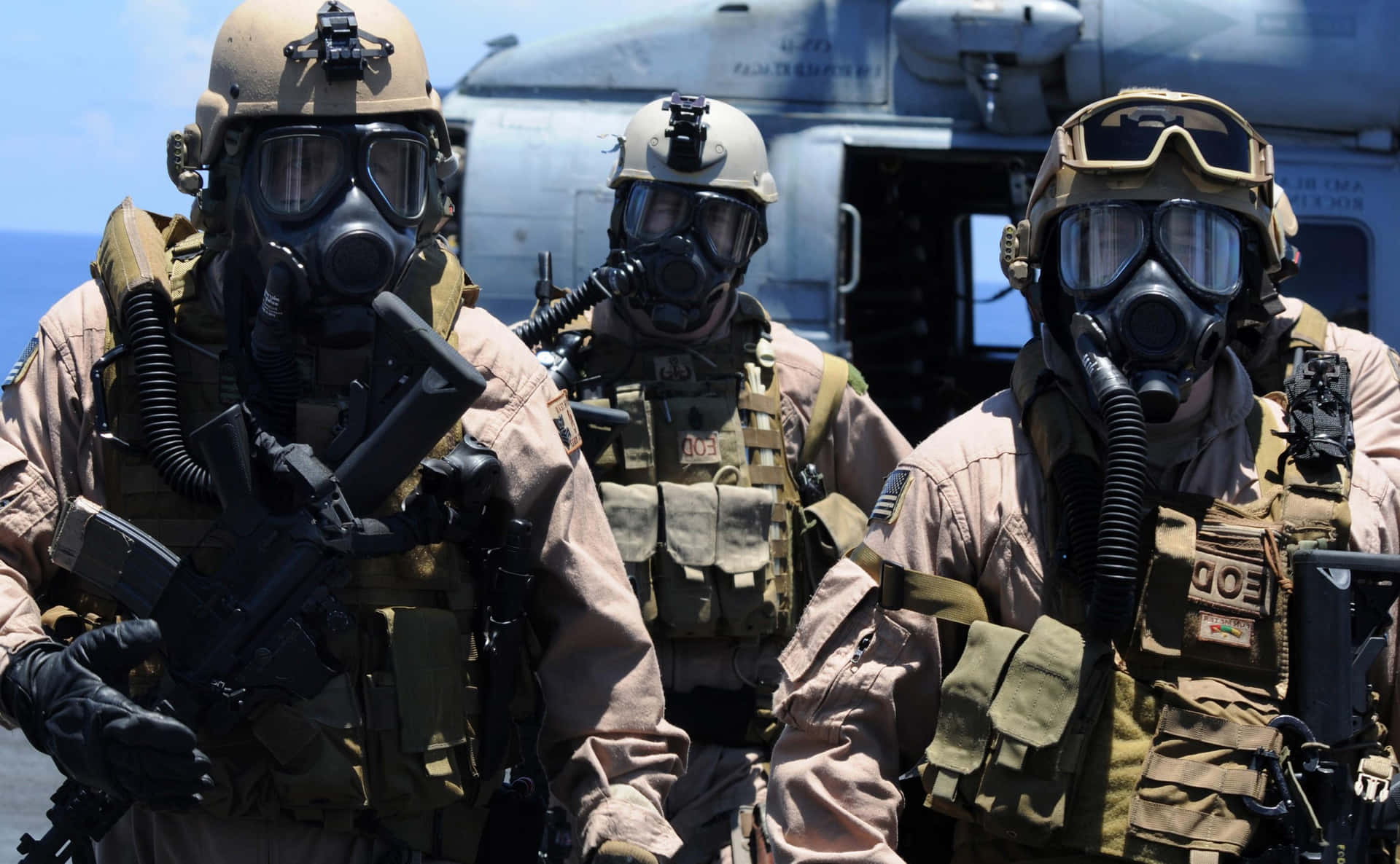 Three Marines In Gas Masks On A Helicopter Wallpaper