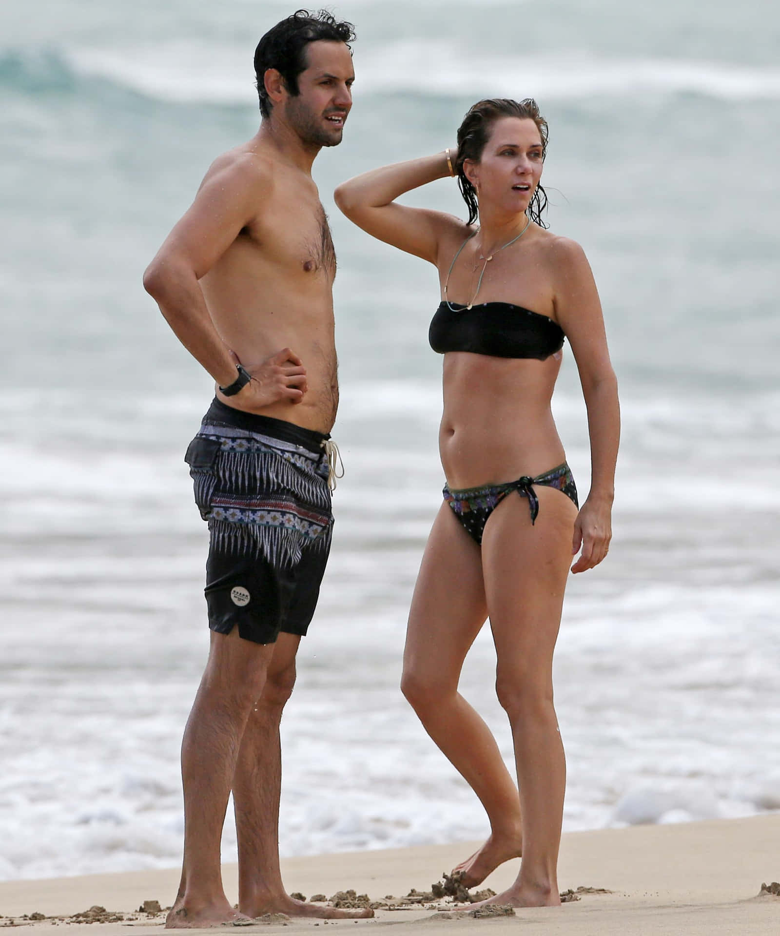 A Man And Woman Standing On A Beach
