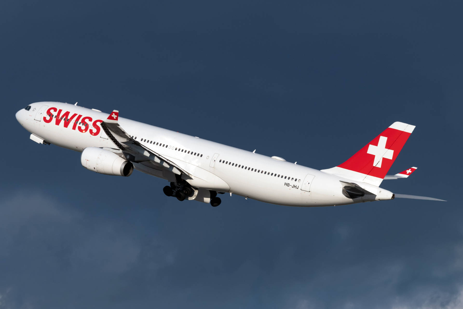 Aviónde Swiss Airlines Bajo El Cielo Azul Oscuro Fondo de pantalla