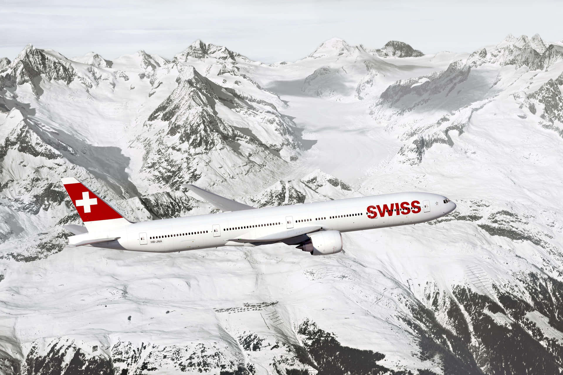 Swiss Airplane Over Snowy Mountains Wallpaper