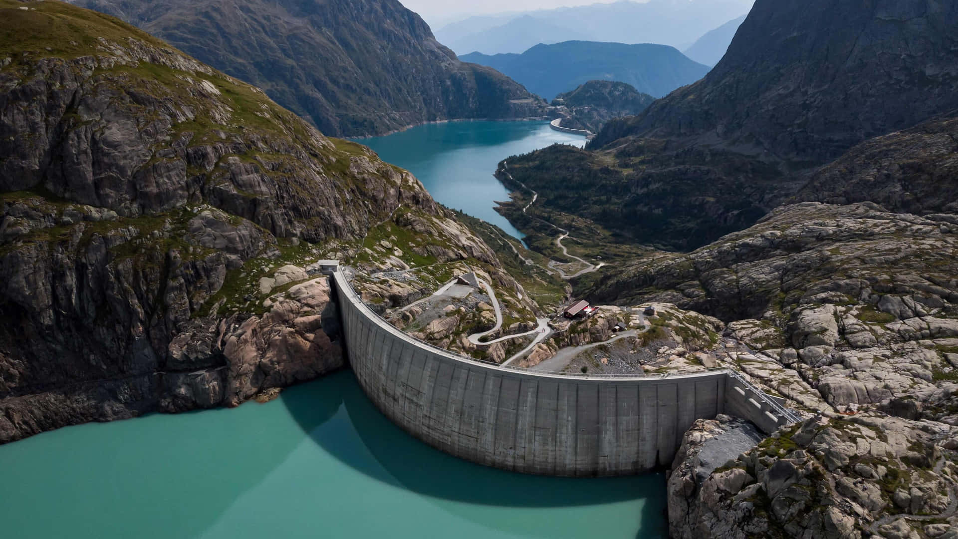 A Dam With A Blue Lake In The Mountains