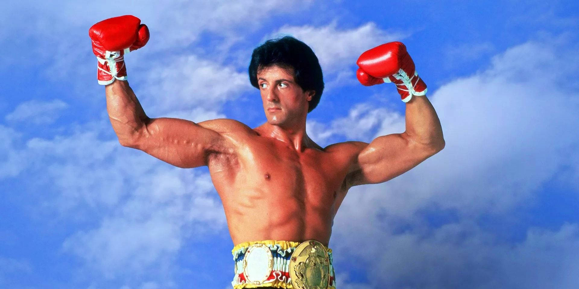 Action Superstar Sylvester Stallone Flaunting Boxing Gloves Wallpaper