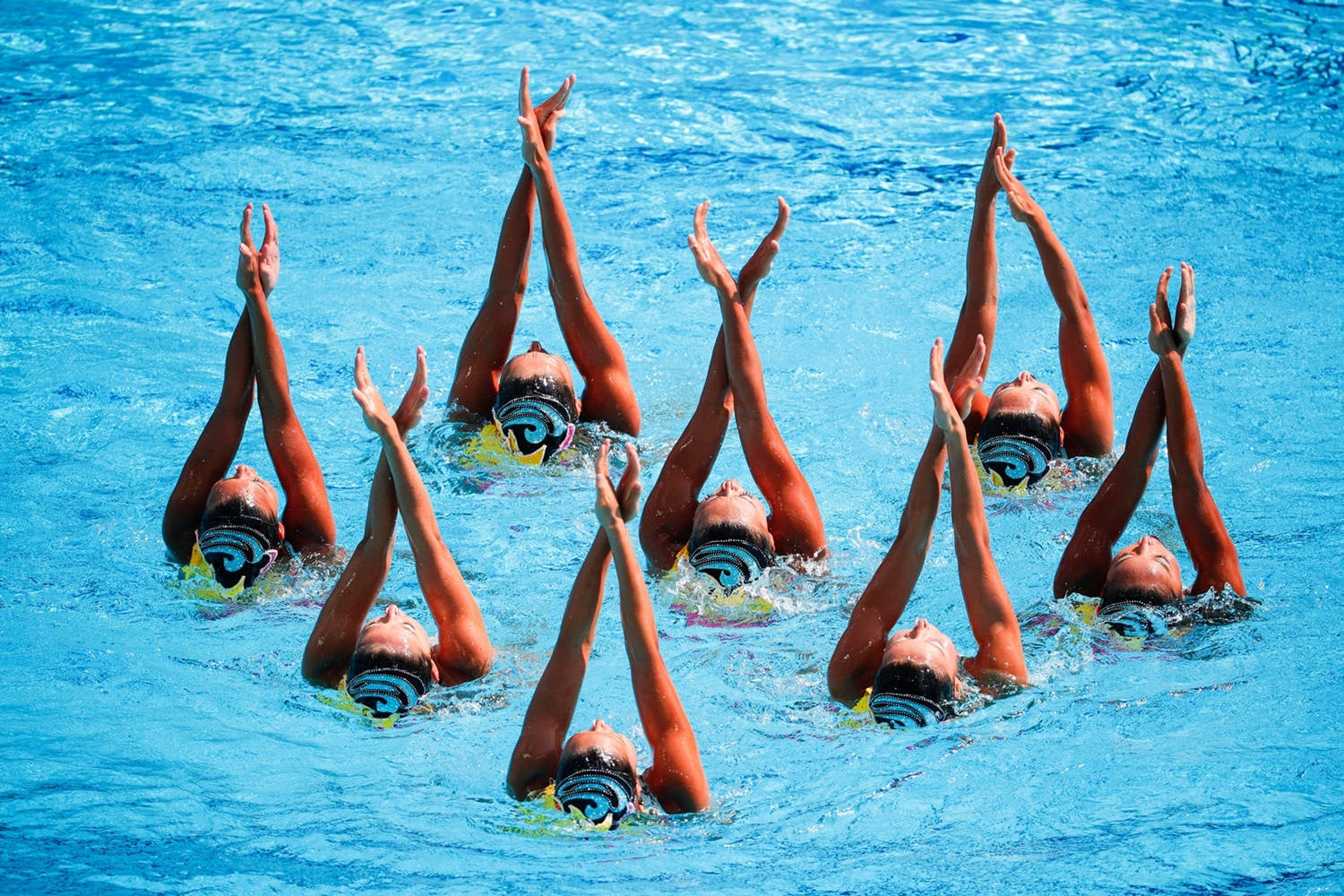 Japanese synchronized swimming team performing intricate routine Wallpaper