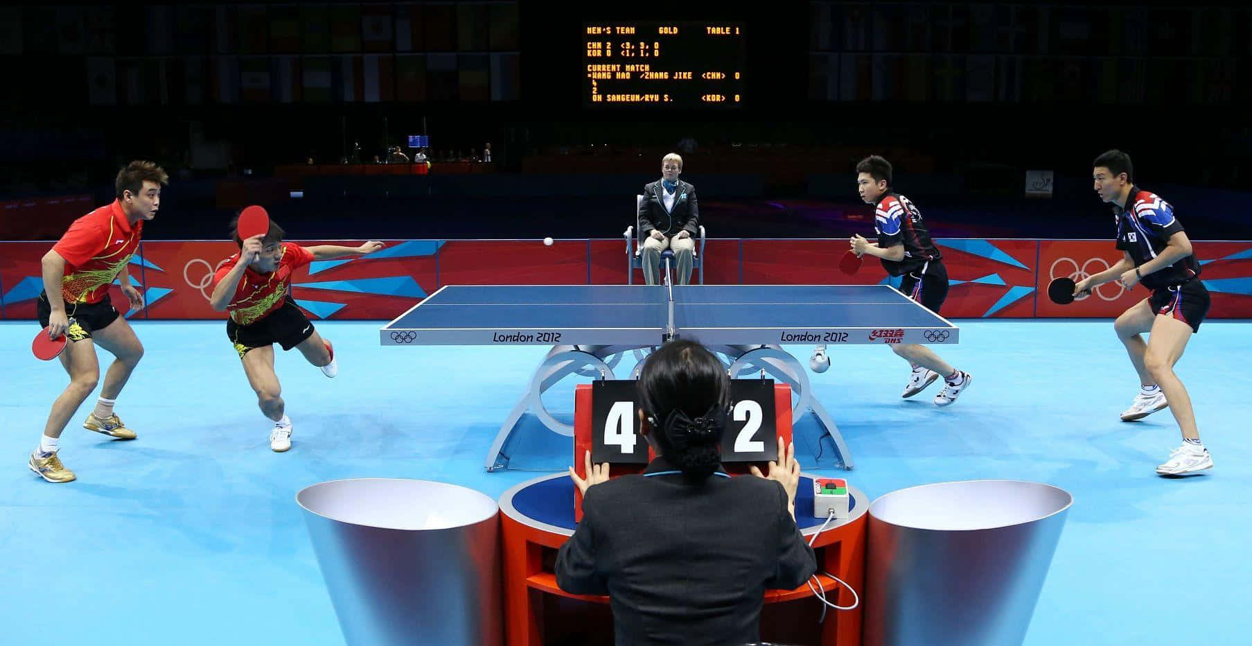 A Group Of People Playing Table Tennis In An Arena