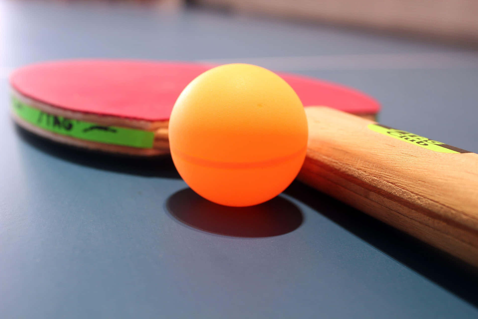 A Ping Pong Paddle And An Orange Ball
