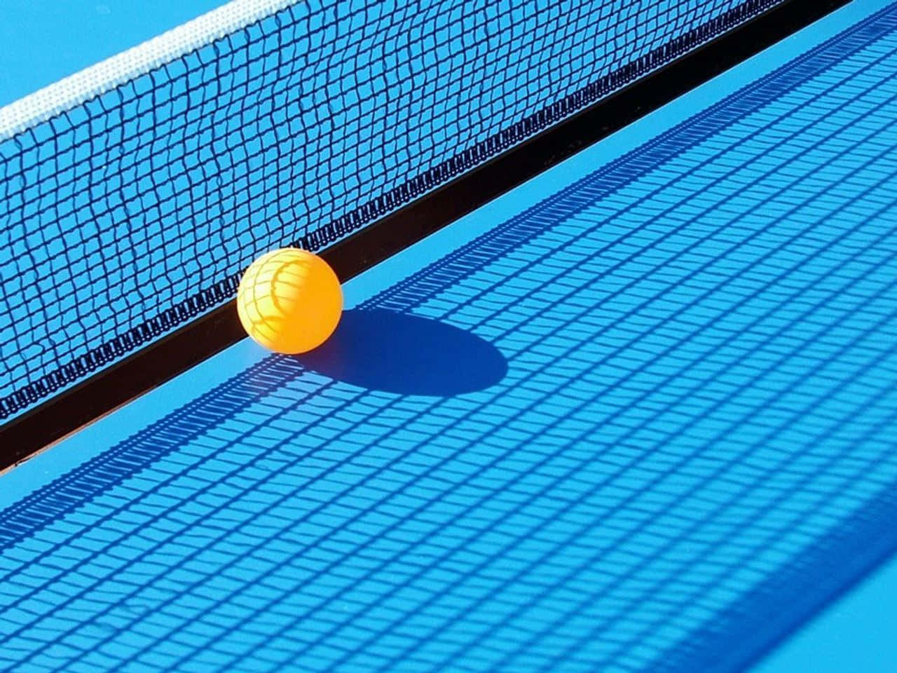A Yellow Ball Is Sitting On A Blue Tennis Court