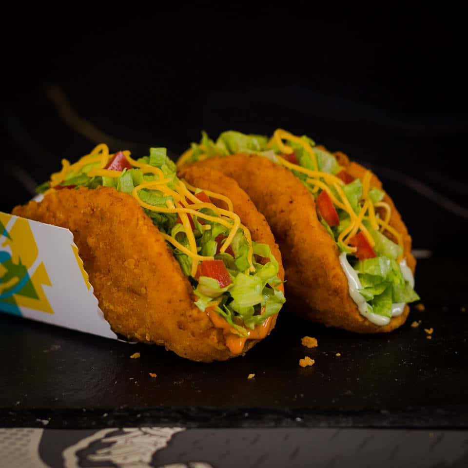 Two Tacos On A Black Table