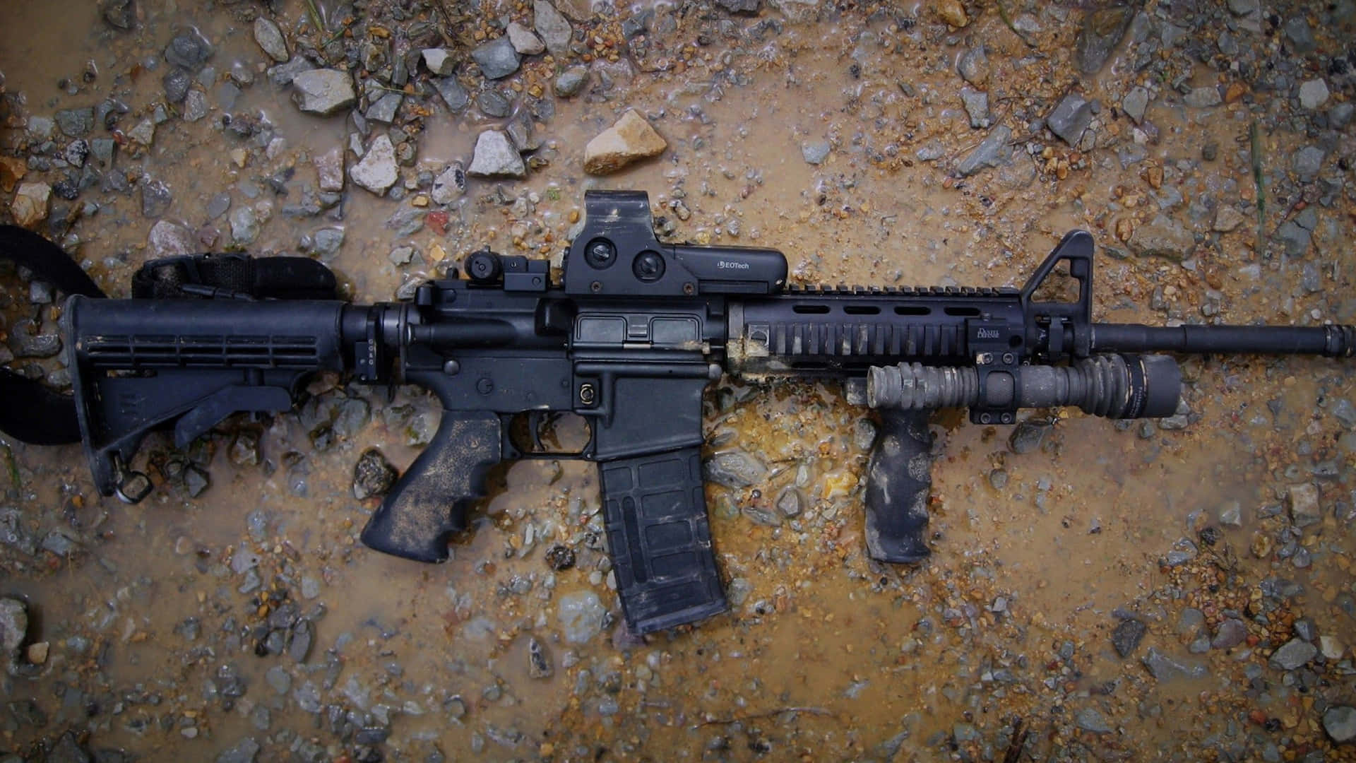 A Black Rifle Is Laying On The Ground Wallpaper