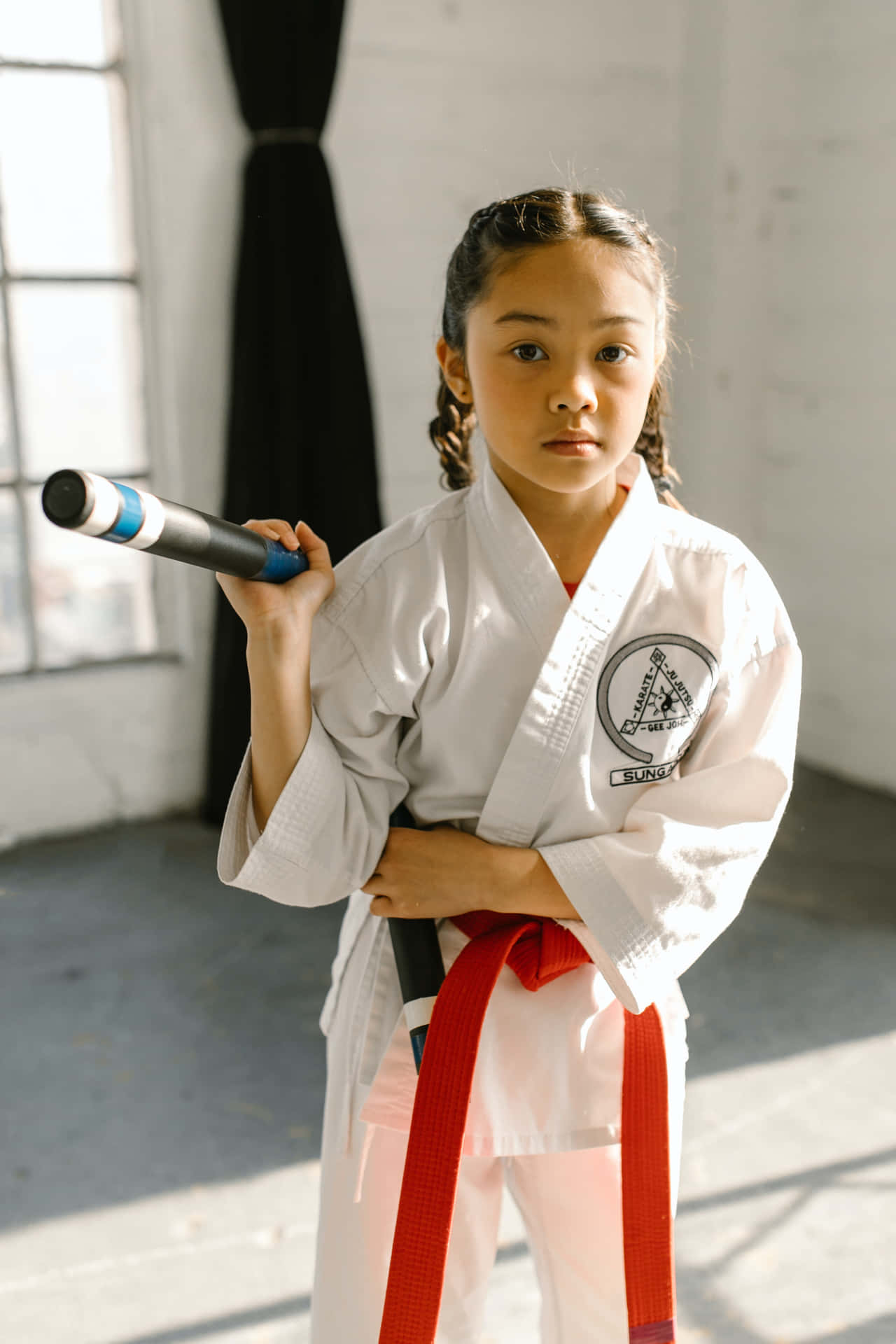 A person in a black and red Taekwondo uniform demonstrating a striking move Wallpaper