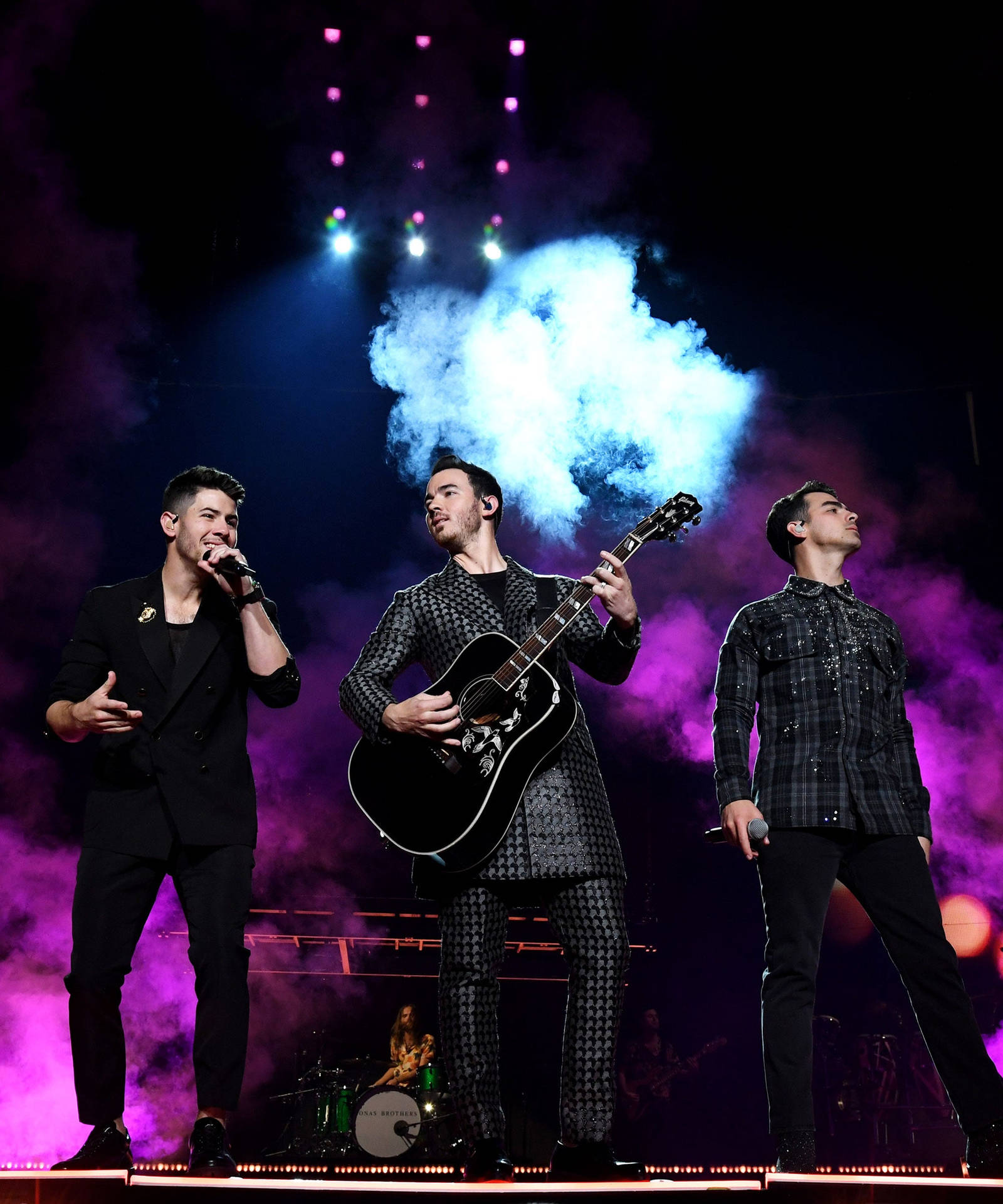 Talented Jonas Brothers On Stage Background