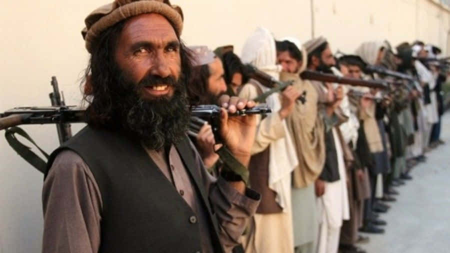 Ungruppo Di Combattenti Armati Dei Taliban Che Camminano Insieme All'aperto.
