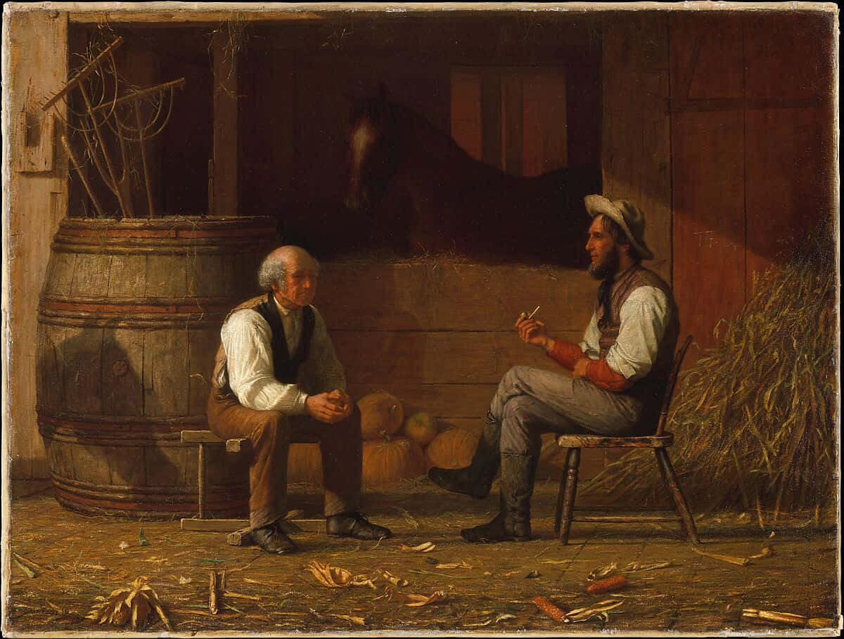 Two Men Sitting In A Barn Talking