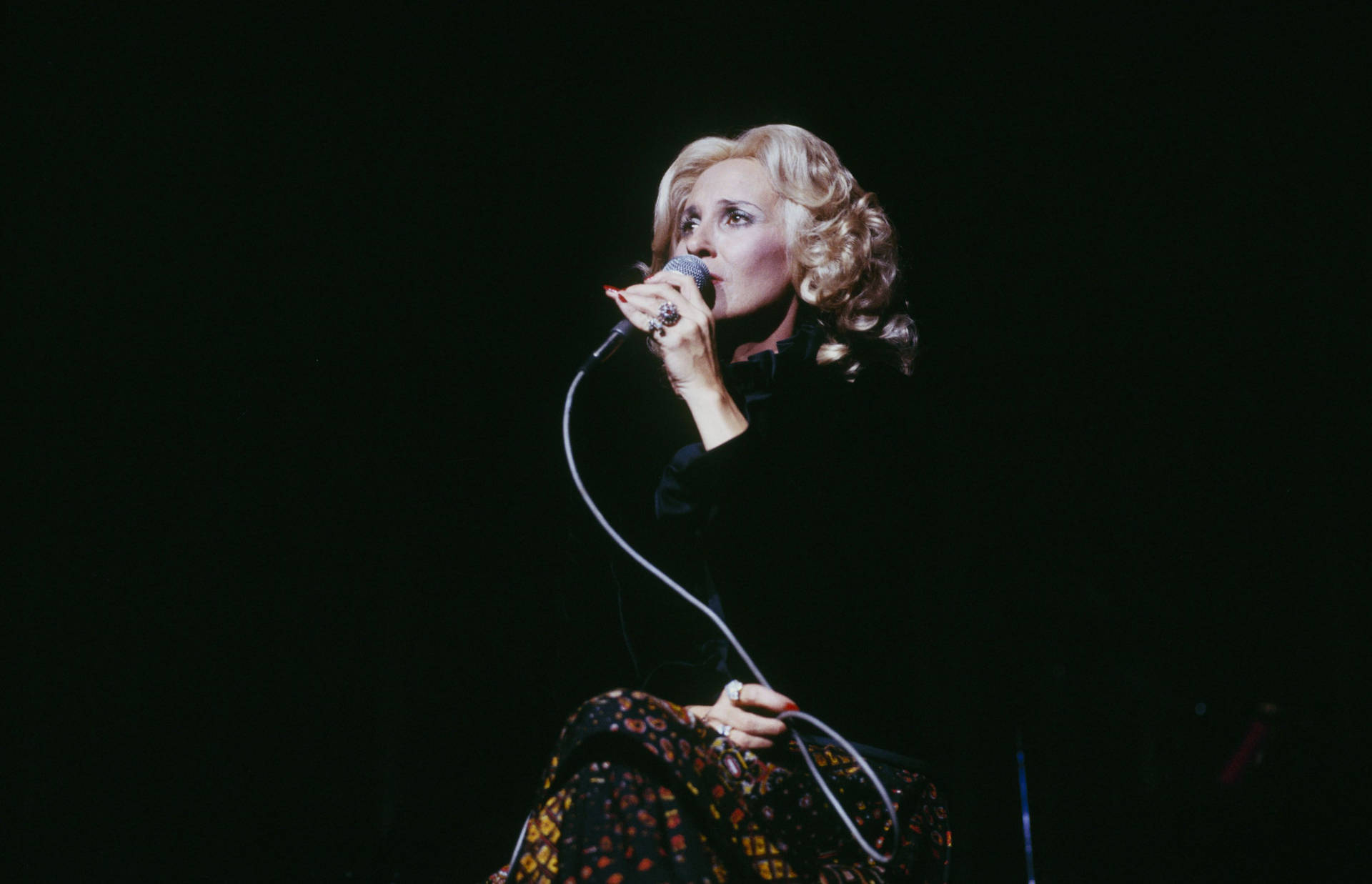 A Regal Moment: Tammy Wynette's soulful performance at a Country Music Festival Wallpaper