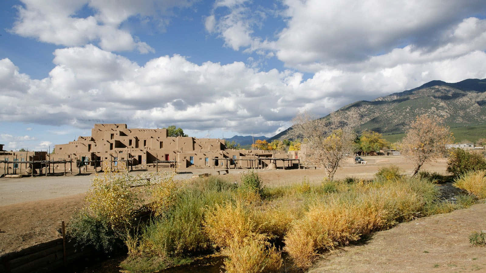 Enthralling View of the Iconic Taos Pueblo Community Wallpaper