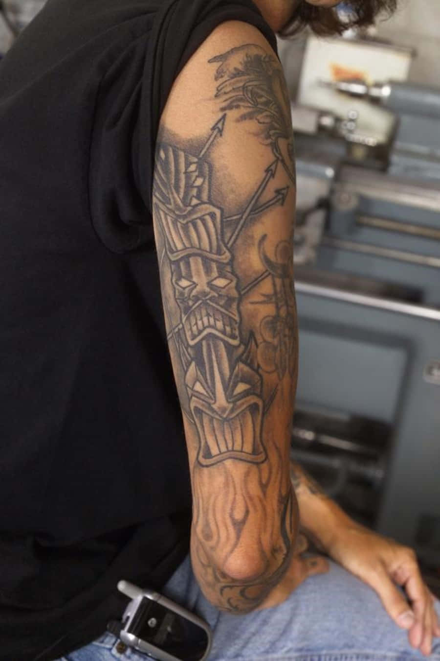 Immaginedi Un Uomo Seduto Con Braccio Tatuato.